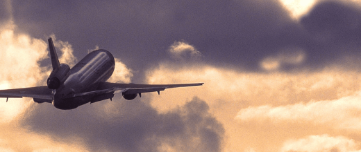 Image of an airplane in the sky under sunlit clouds