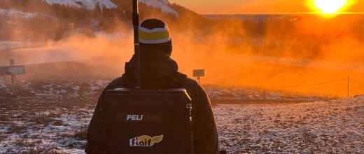 Scientifique portant la Flair box sur son dos dans un environnement naturel au lever du soleil